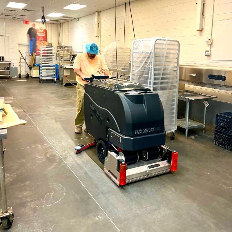 FactoryCat Walk Behind Floor Scrubbers Mag-HD kitchens concrete - https://assets.factorycat.com/demoImages/2025/april/Mag-HD-Walk Behind Floor Scrubbers-kitchens-concrete-Savanah-USA-898.jpg - 800 - 800 - 898 A FactoryCat Mag-HD Spec Ops walk behind floor scrubber cleaning the concrete floor of the kitchen at a Savanah, Georgia confectioner