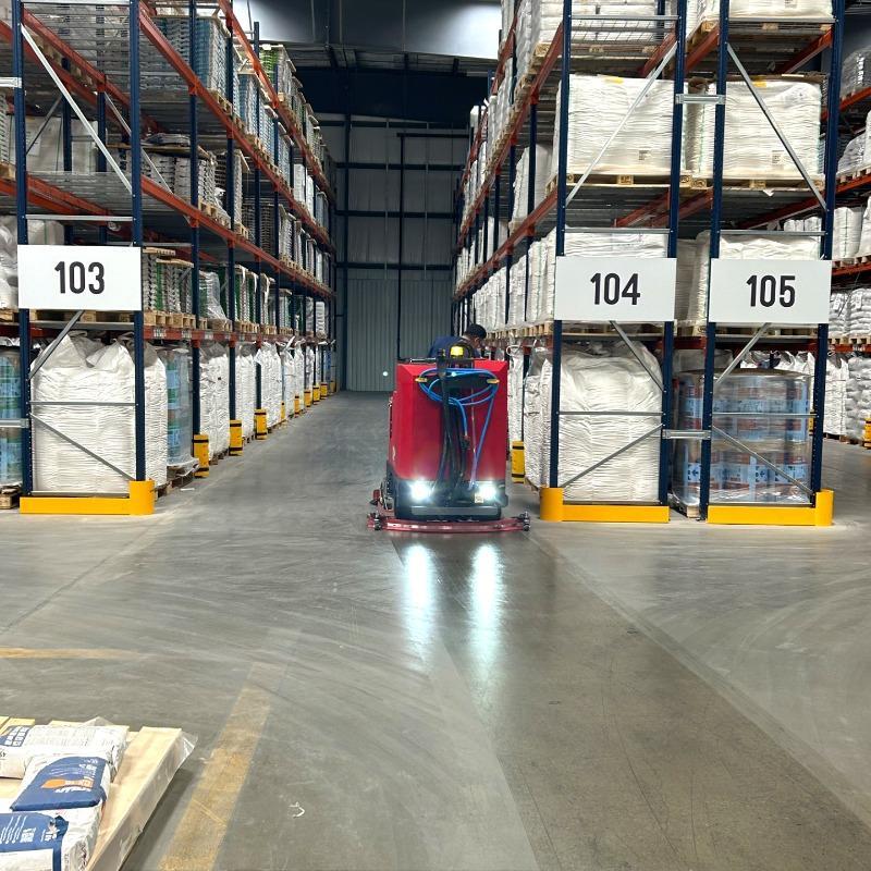 FactoryCat Ride On Floor Scrubbers XR warehouse concrete - https://assets.factorycat.com/demoImages/2025/april/XR-Ride On Floor Scrubbers-warehouse-concrete-Houston -USA-478.jpg - 800 - 800 - 478 A FactoryCat XR battery rider floor scrubber is cleaning the concrete floor of a chemical plant in Houston, TX